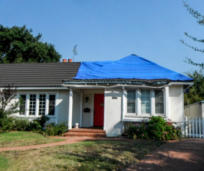 Storm-damaged roof protected with a temporary covering